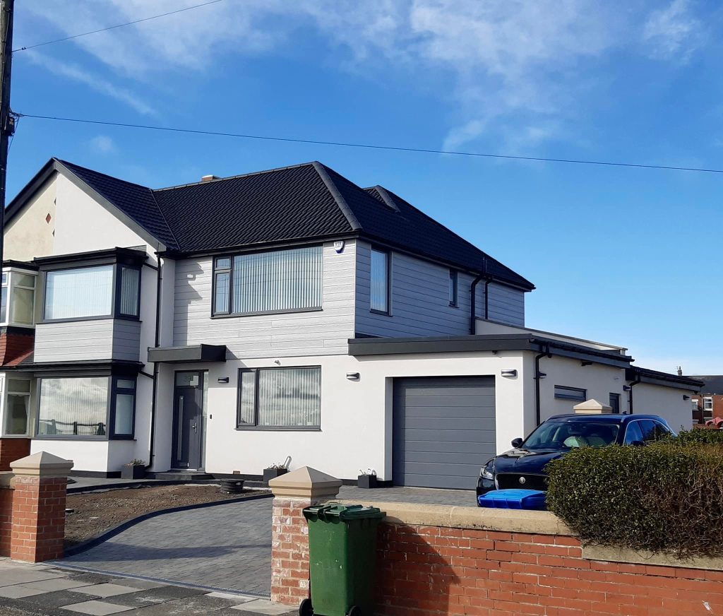 The finished two-storey house extension in Northumberland, with fresh render and new windows