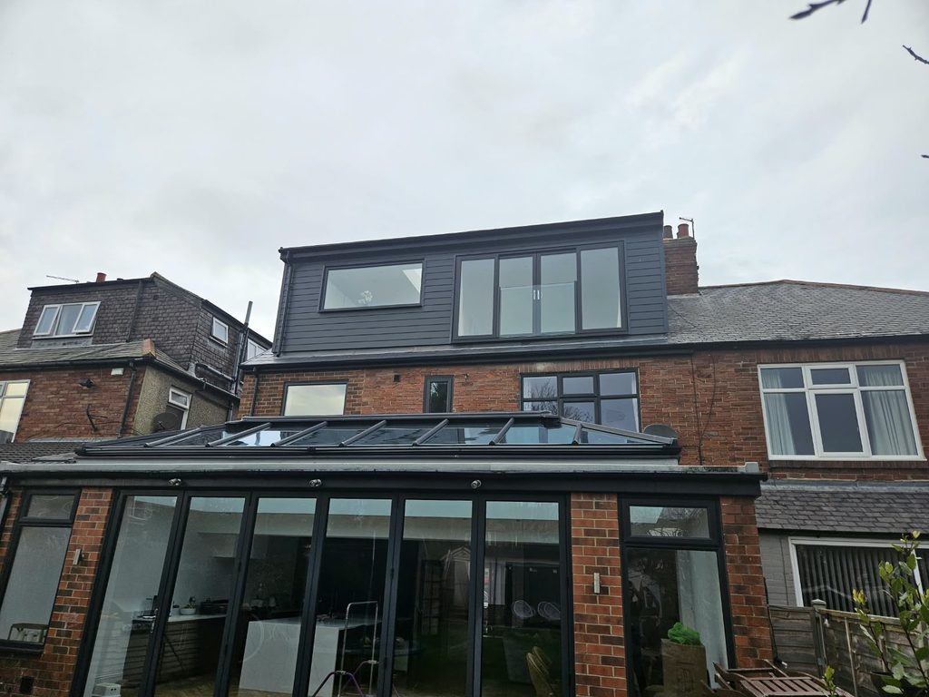 Rear dormer loft conversion in dark cladding, with a Juliet balcony and a wide picture window