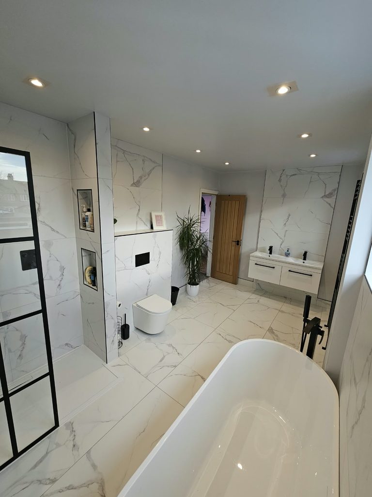 Marble-effect family bathroom with tiled shower niches, a wall-hung WC and a white double vanity