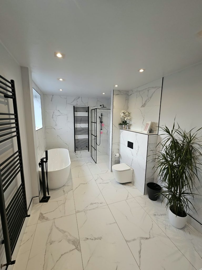 Family bathroom with marble-effect porcelain tiles, a freestanding bath and a black grid shower screen