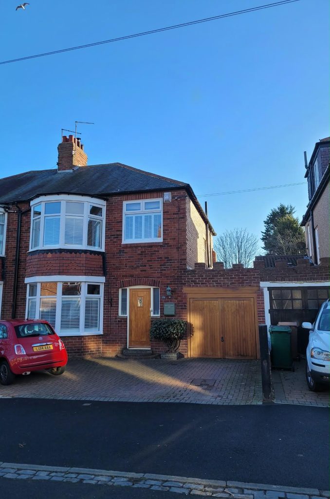 1930s semi-detached house in Whitley Bay before the work, with a single garage and timber garage doors